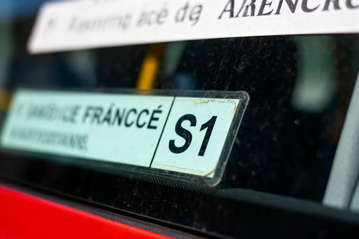Autocollant sur une vitre de voiture avec texte "S1" et "SERVICE FRANCCÉ".