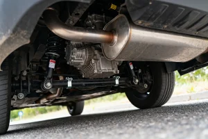 Vue sous un véhicule montrant pot d'échappement potentiellement source de bruit quand je lache l'accelerateur