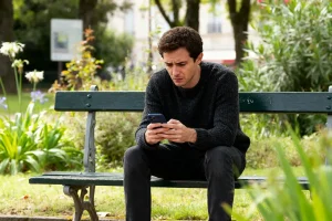 Un homme inquiet vérifie comment savoir si on a une amende sur son téléphone
