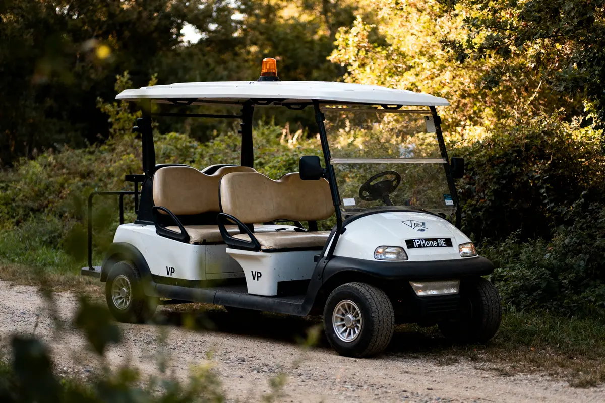 Voiturette de golf deriv vp stationnée sur un chemin forestier ensoleillé