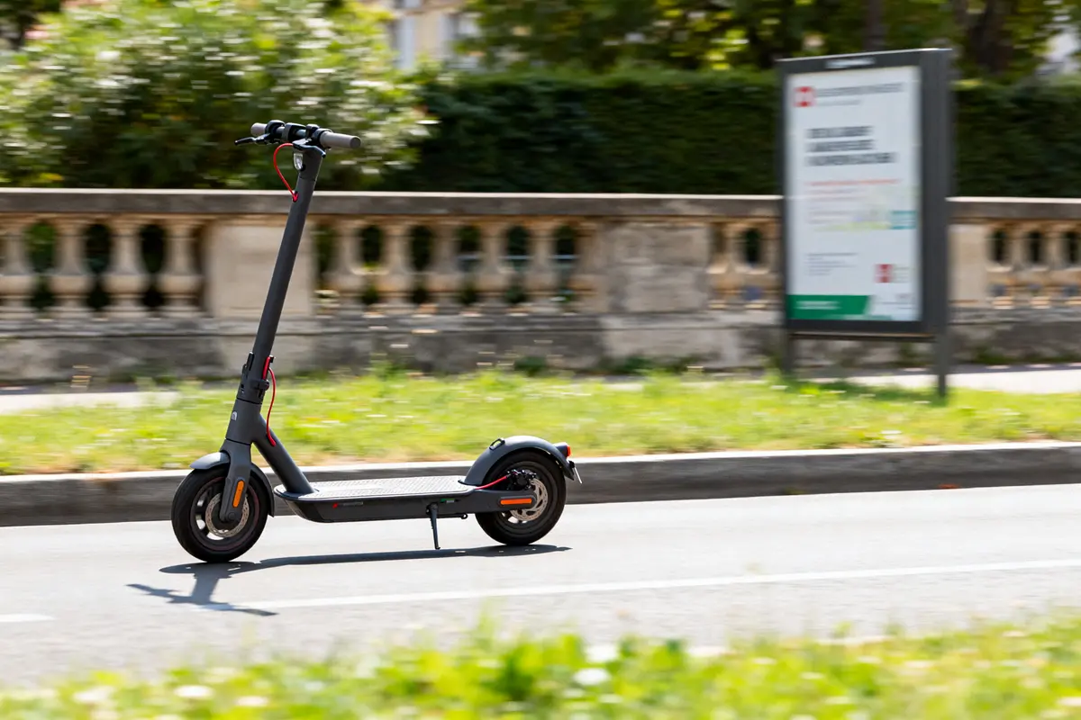 Trottinette électrique Xiaomi Pro 4 noire en mouvement sur route urbaine avis positif