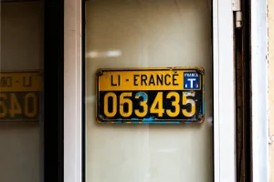 Plaque d'immatriculation ancienne exposée avec code couleur de voiture jaune et bleu