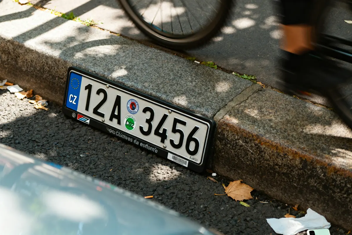 Plaque CZ sur le trottoir près d'un vélo sous un éclairage ombragé