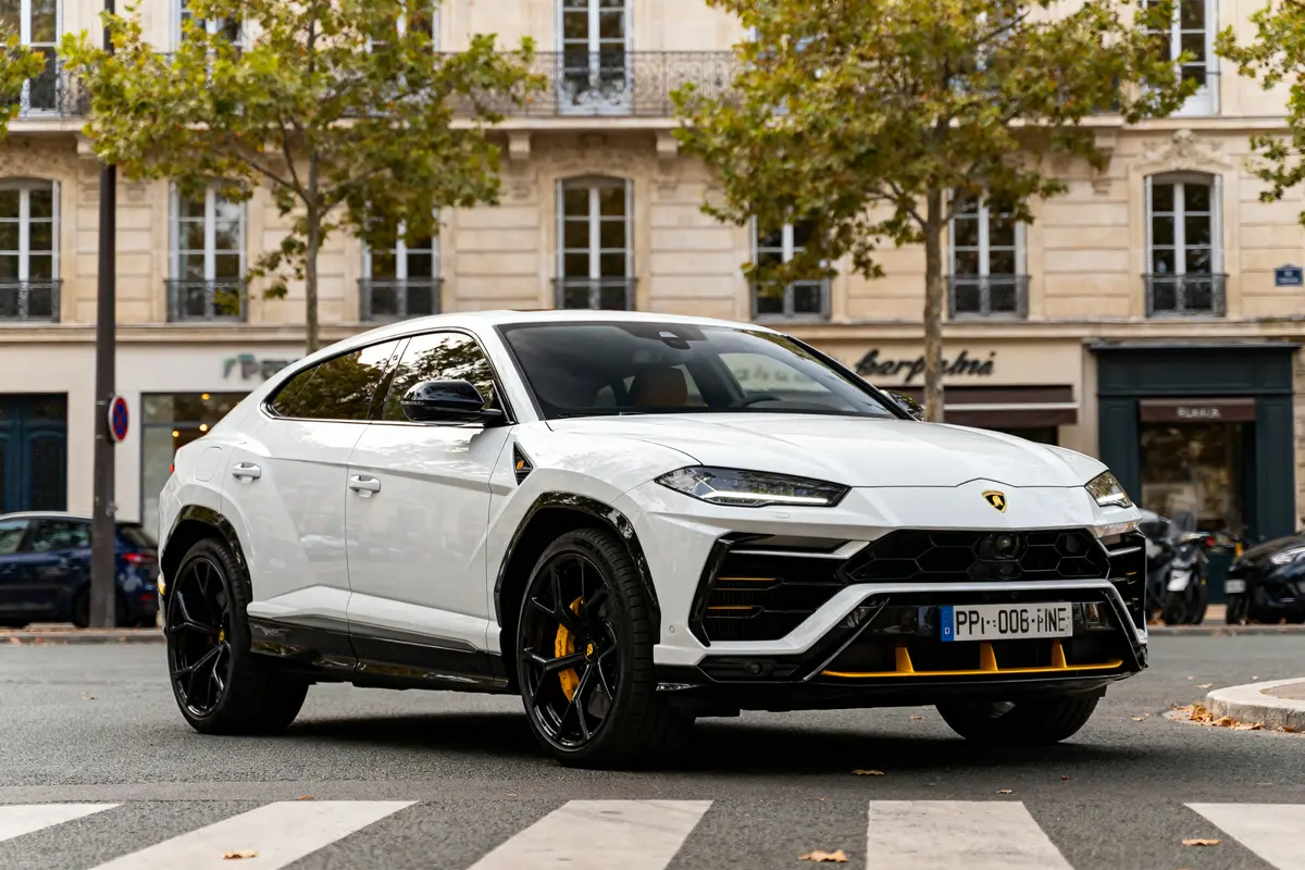 Lamborghini Urus blanche en rue urbaine, reflet du prix d'une Lamborghini Urus luxueuse