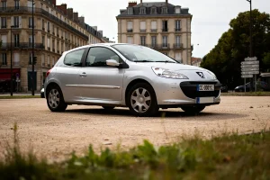 Voiture argentée devant immeubles, exemple de voiture à 5000 euros abordable en ville